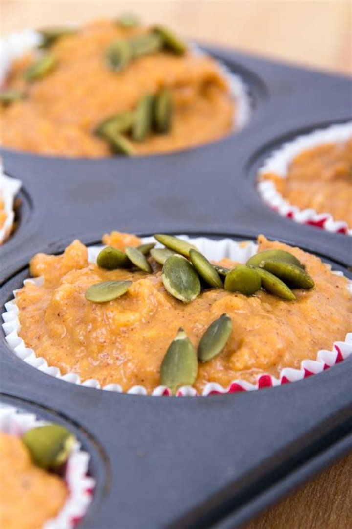 Pumpkin muffins (uncooked) in a muffin tin.