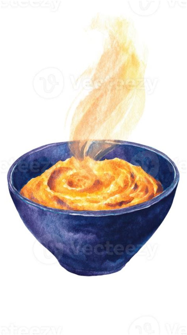 Pumpkin puree being poured into flour in a glass bowl.